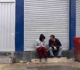 Dos hombres sentados en un andén