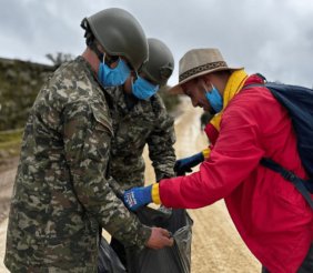 Dos militares sosteniendo una bolsa de basura 