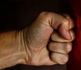 Un puño golpeando una pared roja