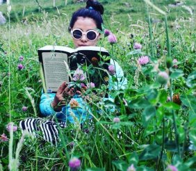Lala Ocampo leyendo en medio de plantas 