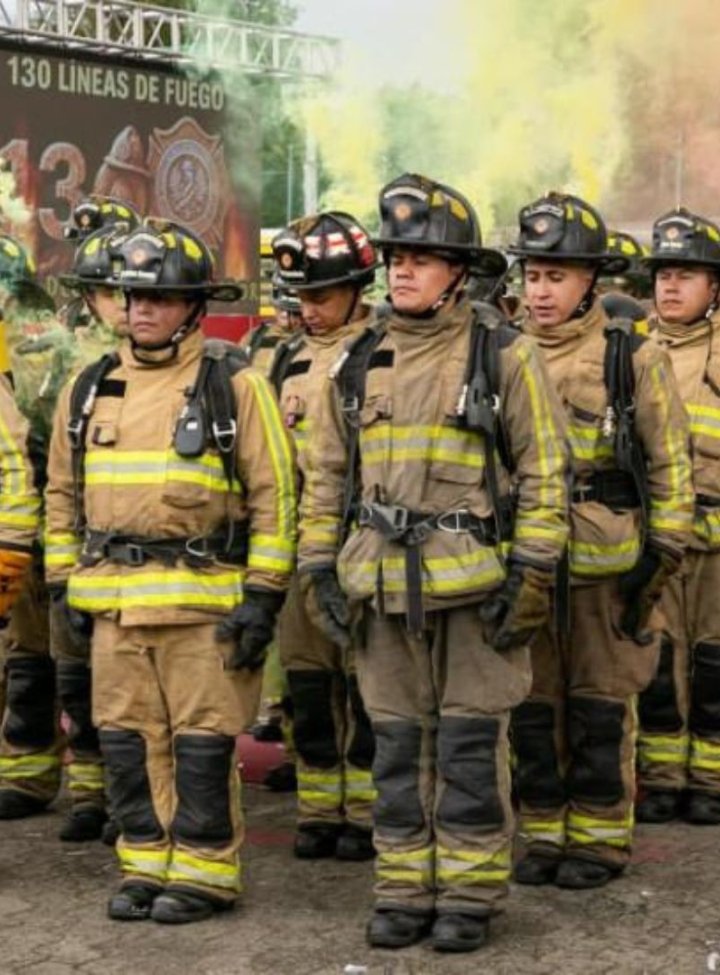 Una fila de hombres en marcha con uniformes de bombero